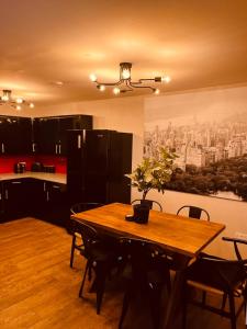 a kitchen with a wooden table with chairs and a painting at 'Woodbury' at stayBOOM in Lancaster