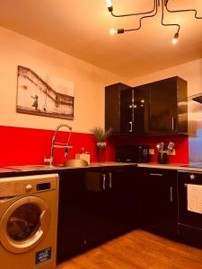 a kitchen with black cabinets and a washer and dryer at 'Woodbury' at stayBOOM in Lancaster