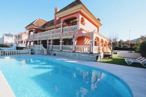 una casa grande con piscina frente a ella en TESS Villa Cari en Alhaurín de la Torre