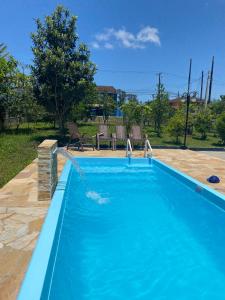 una piscina azul con una fuente de agua en Apartamento em chácara com piscina próximo de praias com internet en São Francisco do Sul