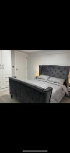 a bedroom with a large bed with a black headboard at The Captains Wheel in Skerries