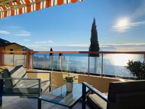 d'un balcon avec vue doté d'une table et de chaises en verre. dans l'établissement Le Vigia-vue mer-terrasse-climatisation-parking, à Menton