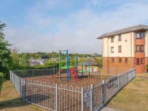 a playground in a yard next to a building at Luxury 2Bed 2Bath Flat in City Centre- Free Parking! in Edinburgh