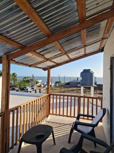 un portico con pergolato in legno e due sedie di Casa para 4 en San Luis - Increible vista al mar!! a San Luis