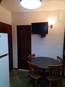 cocina con mesa con sillas y TV en la pared en Apartamento en San Luis - Increible vista al mar!!, en San Luis
