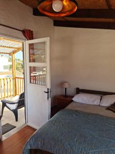 1 dormitorio con 1 cama y puerta a un balcón en Apartamento en San Luis - Increible vista al mar!!, en San Luis