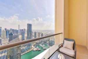 a balcony with a chair and a view of a city at Ultra Luxury JBR Duplex Penthouse - Beach Resorts Neighbourhood in Dubai