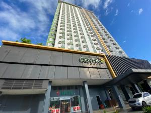 wysoki budynek z samochodem zaparkowanym przed nim w obiekcie Compact Studio Unit @ Centrio Tower w mieście Cagayan de Oro