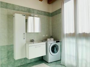 een badkamer met een wasmachine en een wastafel bij Appartamento Donà in Rovigo