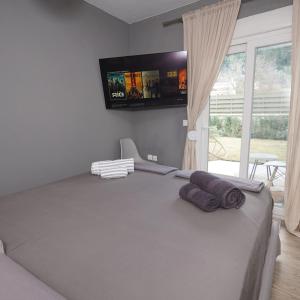 a bedroom with a bed with a flat screen tv on the wall at Villa ELi - Luxury Nature Getaway - Strategically located for Beach Exploration - Onsite Power for Electric Vehicle in Fourka +65 photos