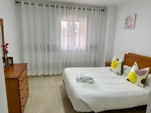 um quarto com uma grande cama branca e uma janela em Apartamento en Marbella em Marbella