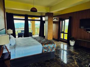 sypialnia z dużym łóżkiem i dużym oknem w obiekcie Hotel Acropolis w mieście Shillong