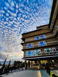 budynek z niebieskimi oknami pod pochmurnym niebem w obiekcie Hotel Acropolis w mieście Shillong