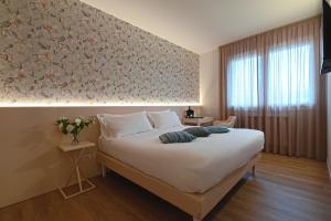 a bedroom with a large white bed and a window at CIVICO 4 affittacamere in Conscio