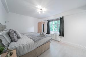 a bedroom with a bed and a window at Beautiful 2 Bedroom House With Spacious Garden BBQ in Brasted