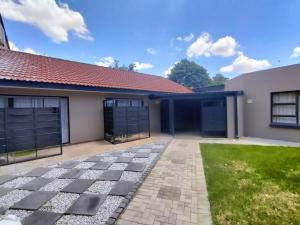 a house with a garage and a driveway at Merinorus Gastehuis in Willows