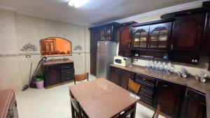 a kitchen with a table and a refrigerator at مدينه 6 اكتوبر حدائق الفردوس الامن العام فيلا ٢٤٧ شارع ٨ in Madīnat Sittah Uktūbar