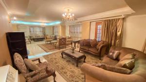 a large living room with couches and a chandelier at مدينه 6 اكتوبر حدائق الفردوس الامن العام فيلا ٢٤٧ شارع ٨ in Madīnat Sittah Uktūbar