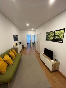 ポルトにあるDown Bonjardim Apartmentsのリビングルーム(緑のソファ、薄型テレビ付)