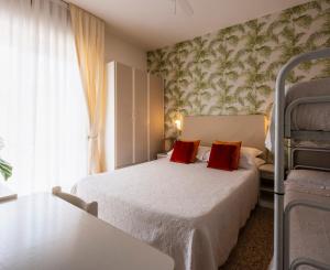 a bedroom with a bed with two red pillows at Hotel Maarea in Milano Marittima +33 photos