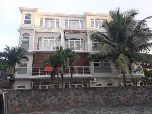 a building with palm trees in front of it at Ocean Drive Studio, next to the Beach in Grand-Baie