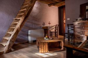a room with a staircase and a table and chairs at Agribenessere Agli Abatti in Barge