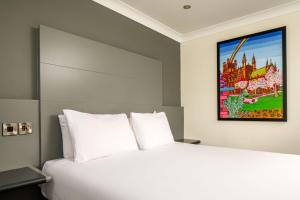 um quarto com uma cama branca e um quadro na parede em Mercure Chester Abbots Well Hotel em Chester