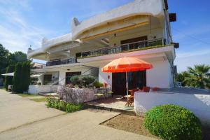 a house with an orange umbrella in front of it at Solon and Teo Summer House in Avdira beach in Paralía Avdhíron