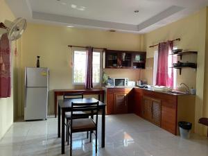 eine Küche mit einem Tisch und einem Kühlschrank in der Unterkunft Bangtao Hello House in Strand Bang Tao + 15 Fotos