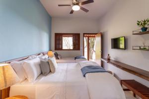 a bedroom with two beds and a ceiling fan at Pousada Rávis - Café e Descanso in Sabará