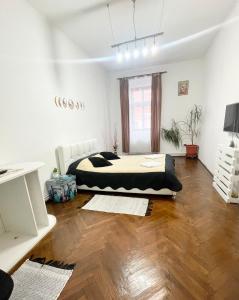 a bedroom with a bed and a wooden floor at Alex Com in Sibiu