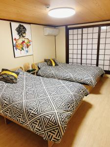 dos camas sentadas una al lado de la otra en una habitación en 悠雅軒, en Osaka