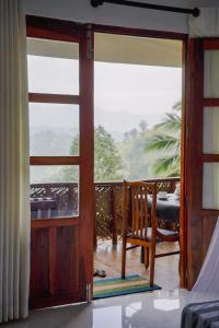 an open door to a balcony with a table and chairs at Ice Age Cottage in Ella