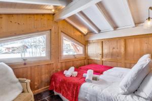 two beds in a room with wood paneling at Beautiful suite with garden at the foot of the slopes - Welkeys in Megève