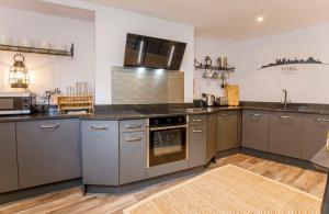 a kitchen with stainless steel appliances and wooden floors at The Holgate Hideaway with Hot Tub in York