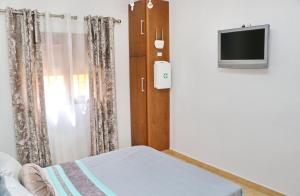 コニル・デ・ラ・フロンテーラにあるCasa Independiente Conilのベッドルーム1室(ベッド1台、壁にテレビ付)