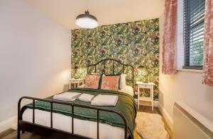 a bedroom with a bed with a floral wallpaper at The Holgate Hideaway with Hot Tub in York