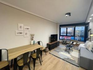 ein Wohnzimmer mit einem Tisch und einem Sofa in der Unterkunft Housingcoruña ORILLAMAR in A Coruña