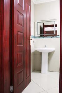 a bathroom with a red door and a sink at Matola View Residence in Matola