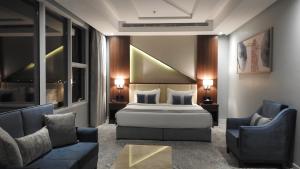 a bedroom with a bed and two chairs and a couch at فندق ليفيل ناين Level Nine Hotel in Jeddah