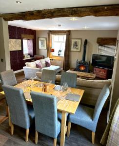 a dining room with a table and chairs and a couch at The Old Dairy - Brosterfield Farm in Eyam