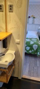 a bathroom with a sink and a bed in a room at Erzscheidergaarden Hotell in Røros