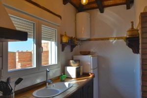 een keuken met een wastafel, een raam en een koelkast bij La Esperanza in Medina Sidonia +11 foto's