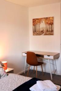 a desk in a room with a bed and a chair at Lovely staycation with family FREE Parking & WiFi in Beeston