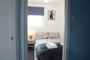 a bedroom with a bed with two feet on it at Lovely staycation with family FREE Parking & WiFi in Beeston