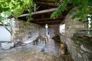 een stenen gebouw met een tafel en een bank erin bij Aronia Stone House in Lafkos