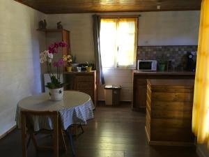 a kitchen with a table with a vase of flowers on it at Ti kaz Hoareau in Salazie