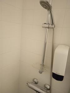 baño blanco con ducha con cabezal de ducha en Ellivuori. Ellin Pooli 4, en Sastamala
