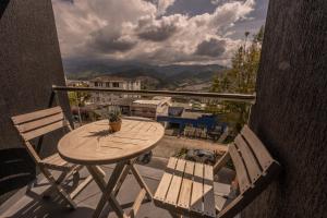 einen Holztisch und zwei Stühle auf dem Balkon in der Unterkunft The Coffee Club in Manizales