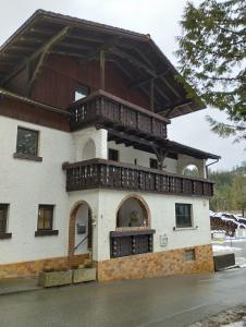 a building with a balcony on top of it at Pension zur Hammermühle in Wallenfels